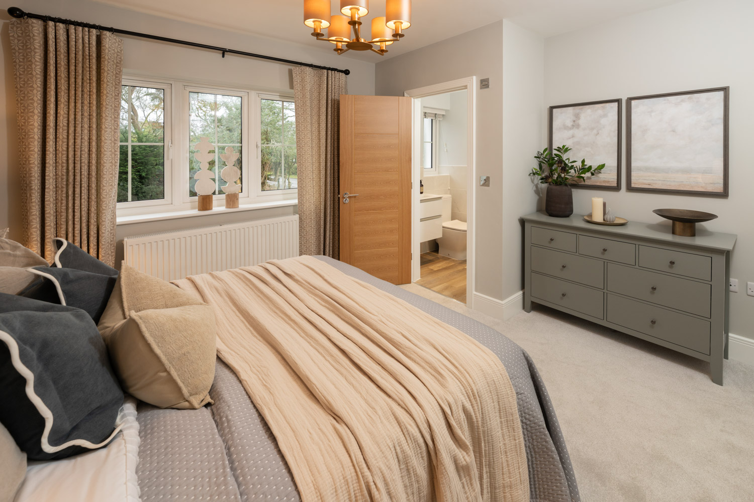blue and cream coloured bedroom with window to the left. made up bed and door opening to en-suite shower to the rear